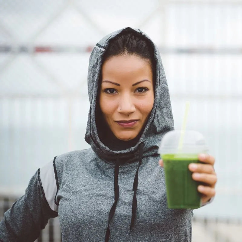 Frau mit Daily Green in der Hand - Sooperfood lässt dich wieder munter werden